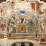 Apsis mit Fresken von Pierpalma da Fermo (ca. 1470). Die Szene zeigt die wundersame Entdeckung einer Kamee durch die Hirtin Chiarina (Chiara Valente), die die Namespatronin des Sanktuariums ist. Die Kamee, die als ein wundersames Bild der Jungfrau identifiziert wurde, wird in einer Prozession im Reliquiar von Pietro Vannini herumgetragen. Die Erzählung findet unter Anwesenheit Christi statt, der zentral in einer Mandorla thront, umgeben von musizierenden Engelschören und den Aposteln. Foto: Giovanni Lattanzi