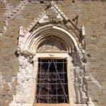 Der Eingang nach den Erdstößen (Juni 2017). Die steinernen Dekorelemente und die die Skulpturengruppe der Lünette konnten abgetragen und gerettet werden, ebenso das Mauerwerk wurde gesichert. Foto: Francesco Gangemi